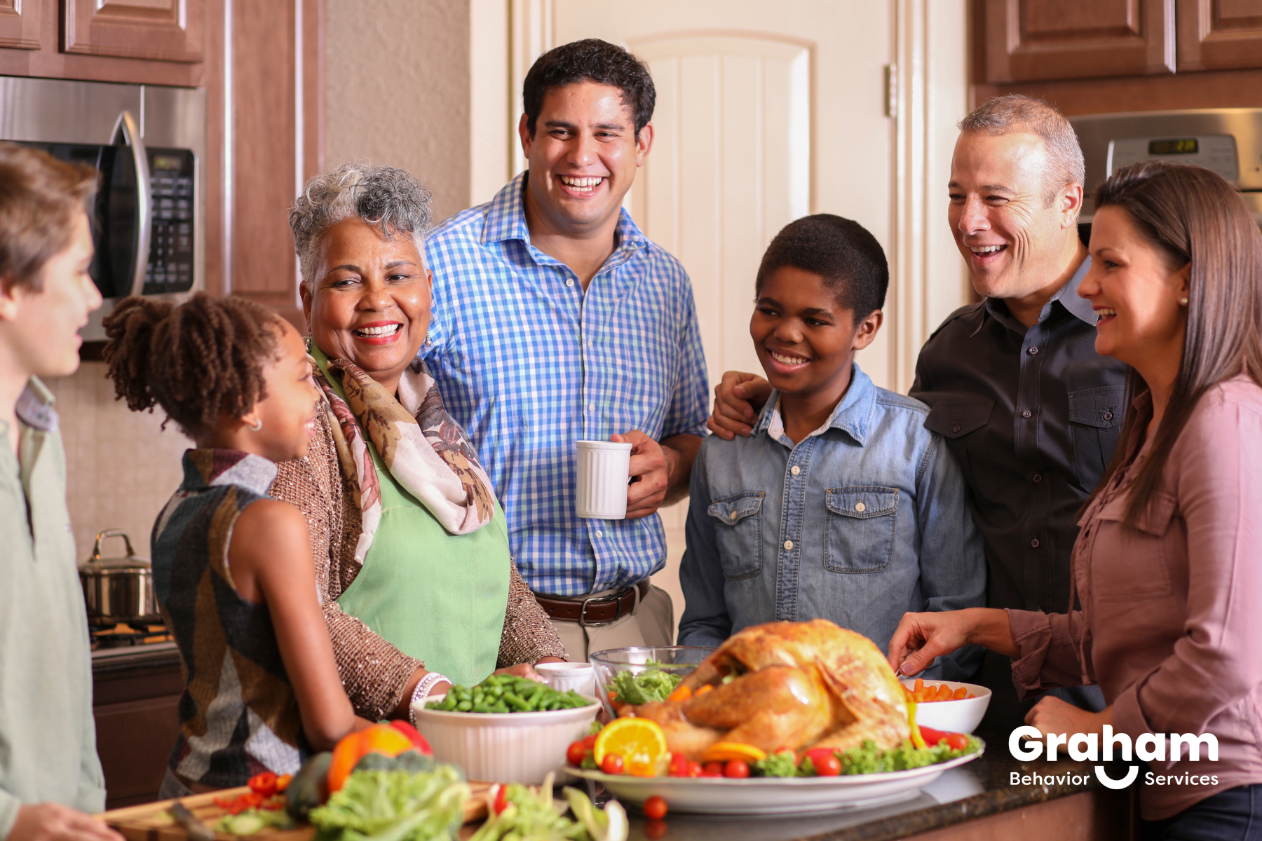 A family standing around a kitchen counter to celebrate Thanksgiving