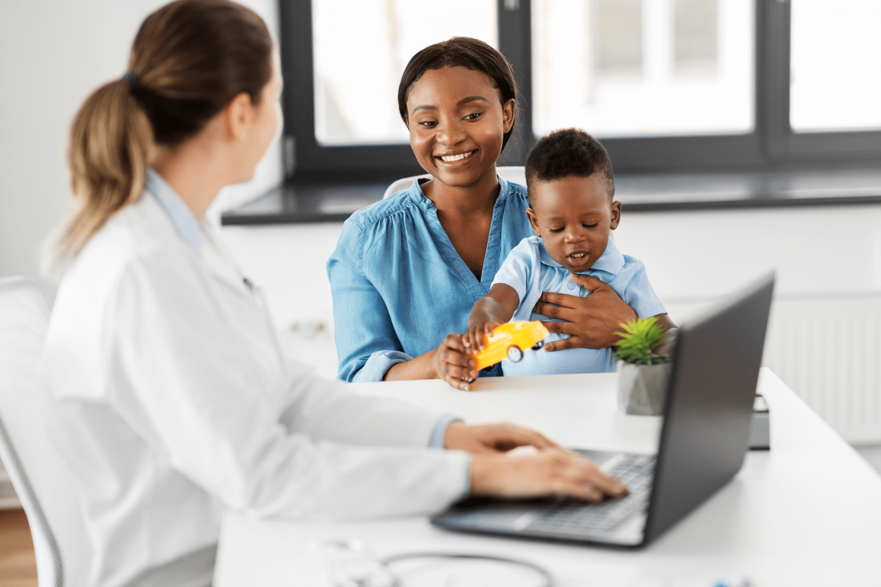 A pediatrician with a mother and her toddler son.